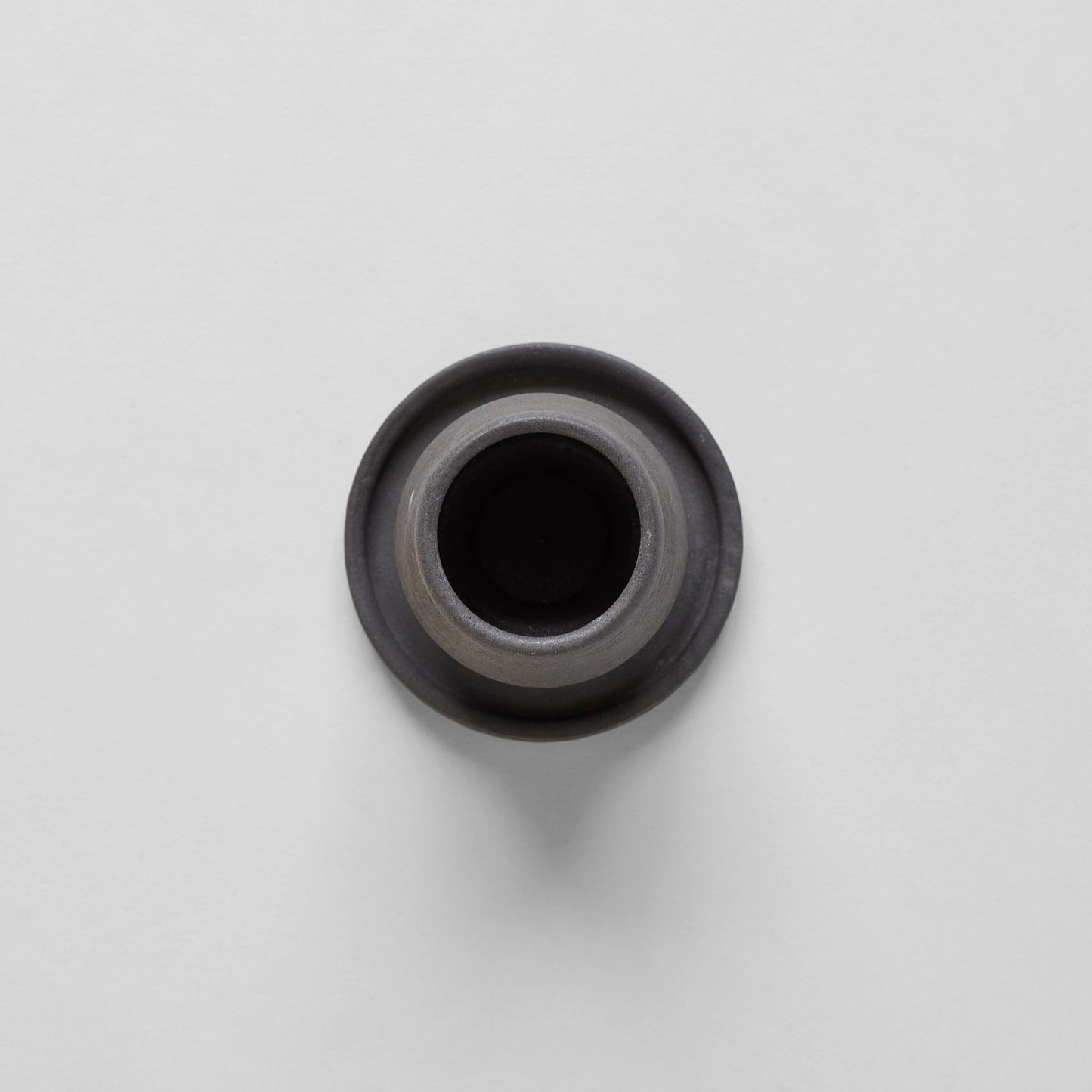 Black ceramic match holder with matches on a gray background. Handmade in the United States and looks lovely as a decorative item. Sold at Huset Shop on Abbot Kinney.