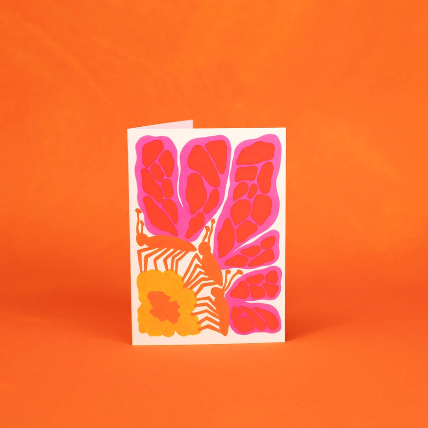 Greeting card with pink floral butterfly design on an orange background