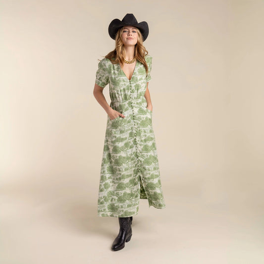Woman wearing a green patterned dress and black cowboy hat and the Darcy Dress with feminine charm and a hint of retro style. Stylish dress