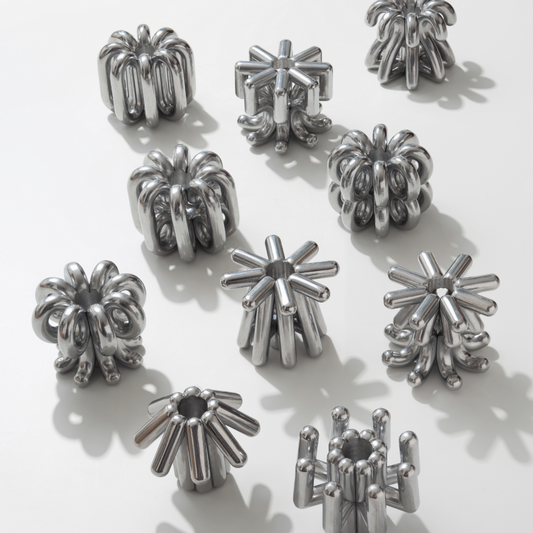 Silver metallic sculptures on a white background, Numbers that shine. The DIGIT candlesticks bring figures to life, ranging from 0 to 9, rotating around the candlestick. Available in solid aluminum, untreated or black lacquered. Whether marking a birthday, an anniversary, or the turn of the year, they let you create meaningful combinations for any occasion. A simple gesture, a lasting impression.