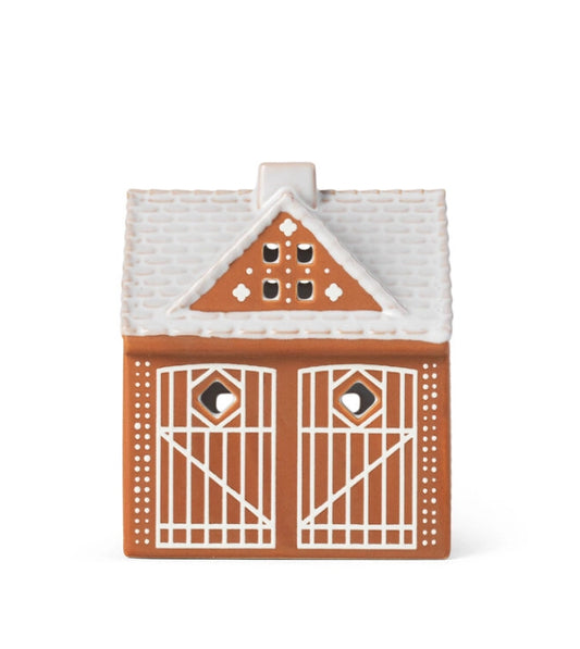 Kähler Gingerbread is a modern gingerbread house from Kähler, where the combination of a charming expression and handmade design traditions meets the warmth of the tealights creating both style and coziness on dark December evenings. The lighthouses have a brown, matte exterior similar to gingerbread dough. They are decorated with white, shiny decorations and have white roofs like frosting. As an important detail, the gingerbread houses are white glazed inside reflecting the warm light from the tealight