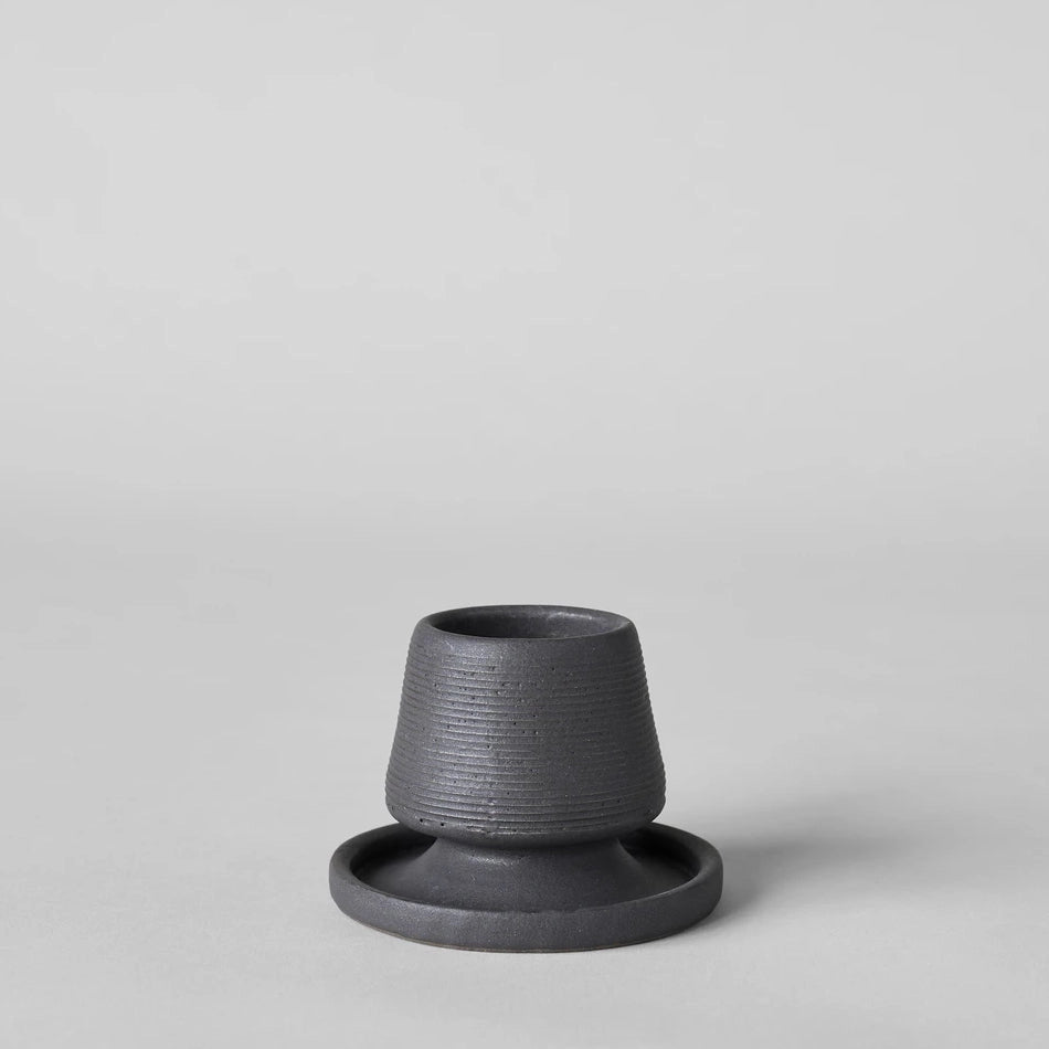 Black ceramic match holder with matches on a gray background. Handmade in the United States and looks lovely as a decorative item. Sold at Huset Shop on Abbot Kinney.