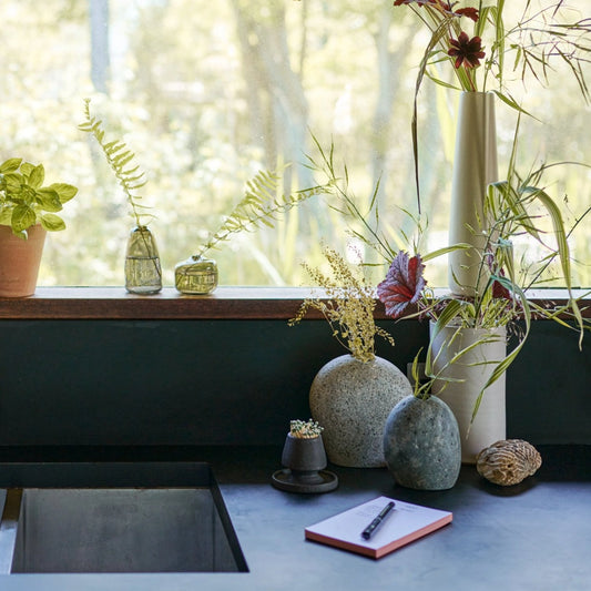 Featuring the Matchstick holder Decorative arrangement of plants and vases on a windowsill with a notebook and pen.