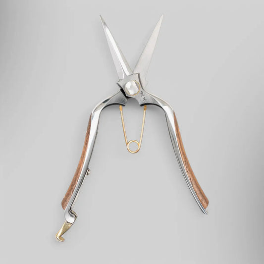 The Niwaki Kurumi Pro Snips are specially designed for precision floral work, making them perfect for delicate cutting and trimming of flowers and stems. With their two-pointed blades, these snips offer unmatched accuracy, ensuring clean, sharp cuts without damaging the plant. Forged from durable KA-70 carbon steel, they are designed for long-lasting performance, making them a valuable addition to any gardener's toolkit.