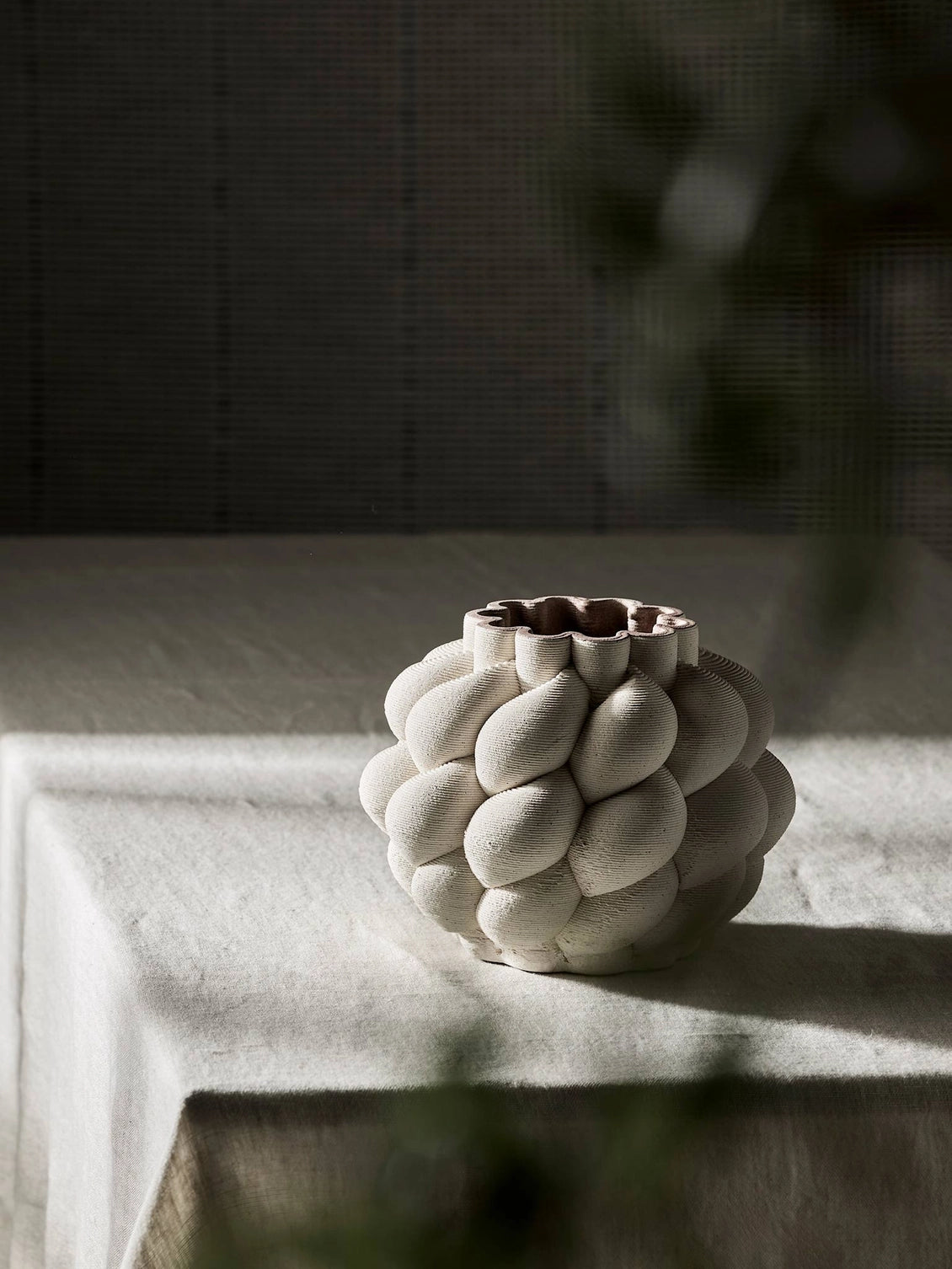 Nuvola is a nature-inspired 3D-printed vase in porcelain clay. It is shaped with soft, curving lines and a rounded profile that creates a lively feel. Through 3D printing, each vase achieves precise lines and an intricate form that is difficult to achieve by hand. The interior is treated to hold water, but as the clay is naturally porous, some moisture may seep through. Therefore, avoid placing it on delicate surfaces.
