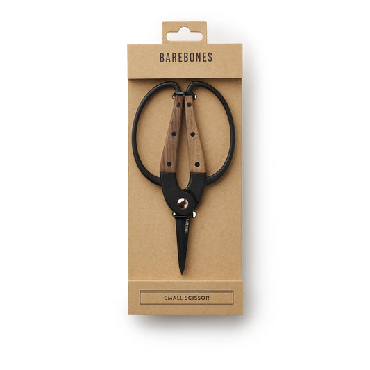 Small scissors with wooden handles in a Barebones packaging on a white background