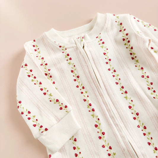 Get little ones cozy in the Layette long sleeve zipper romper, available in four sizes. Featuring a Strawberry pattern with pink scalloped stripes.