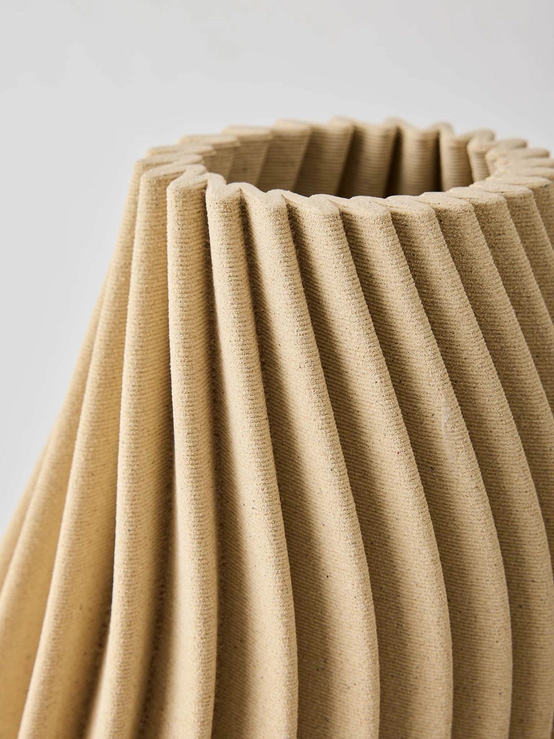 Elegant 3D-printed vase where design meets technology. Each vase features precise lines and intricate details that are difficult to achieve by hand. Made from porcelain clay, the interior is treated to hold water. As the clay is naturally porous, some moisture may pass through, avoid placing it on delicate surfaces. The matte glaze gives a sleek, refined look.