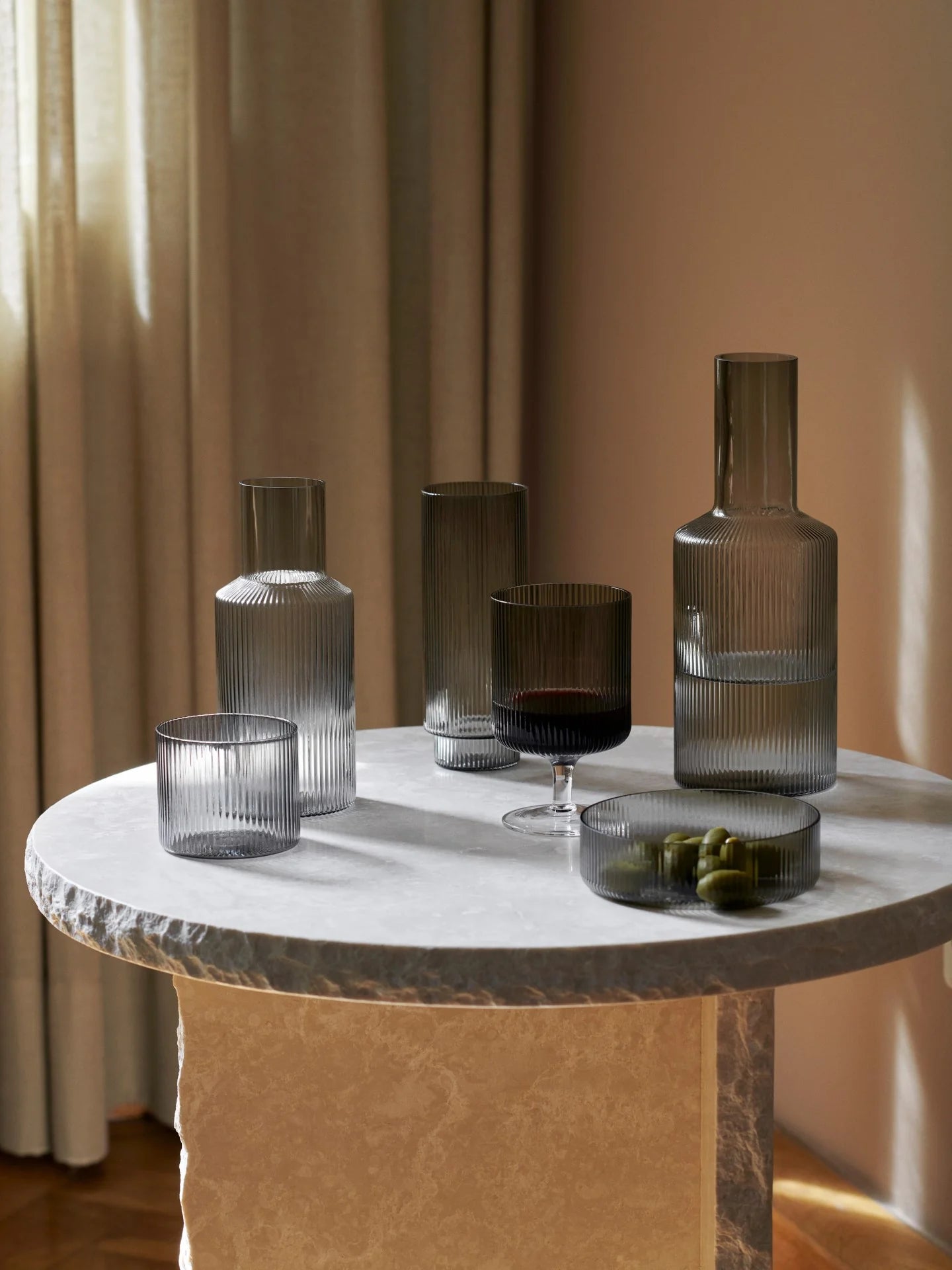 For a casual drink in the garden, the large dinner party or as the fancy supplement at brunch, the Ripple Wine Glass will complete any setting with its unique expression. Mouth-blown into the shape the wine glasses feature the series' characteristic rippled surface and geometric silhouette, making the set of two glasses stack able. Pair the glasses with the rest of the Ripple series and serve your favorite beverage in style.