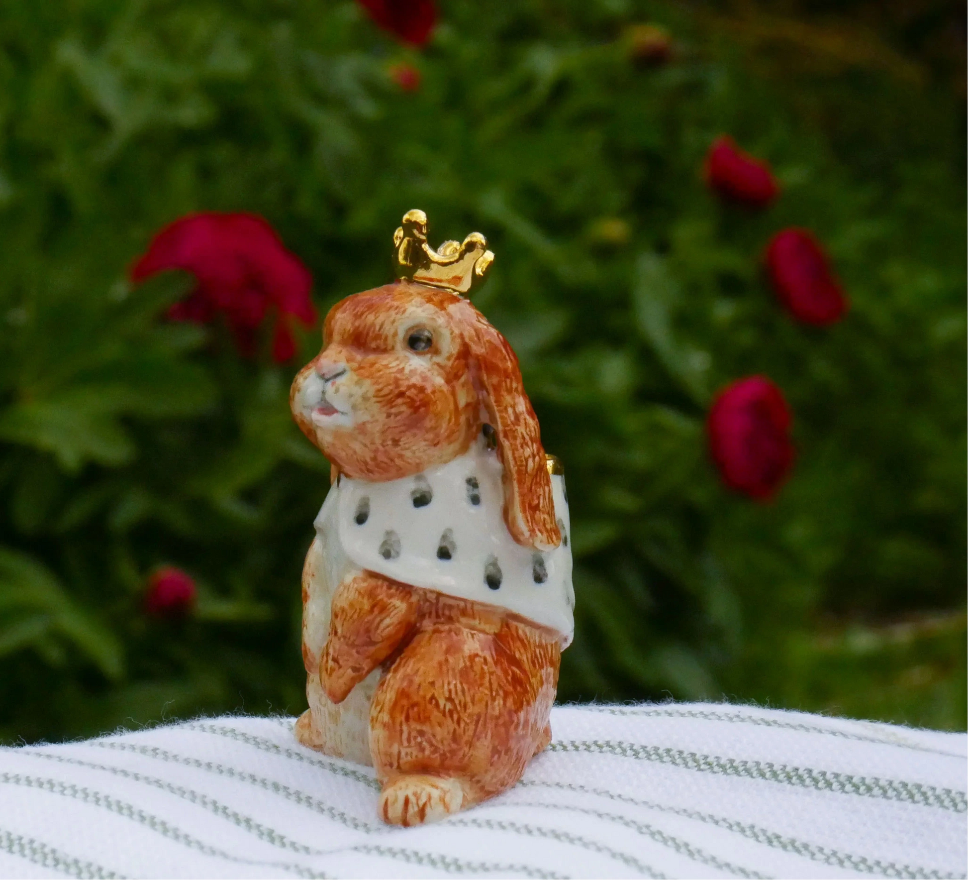 Small rabbit figurine wearing a crown on a striped surface with a '10 Year Coronation Celebration' text in the corner.