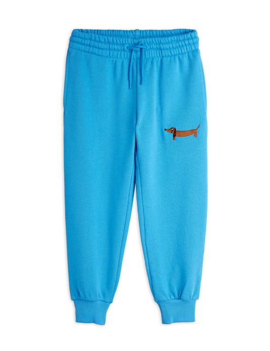 Blue sweatpants with a small embroidered dog design on a white background