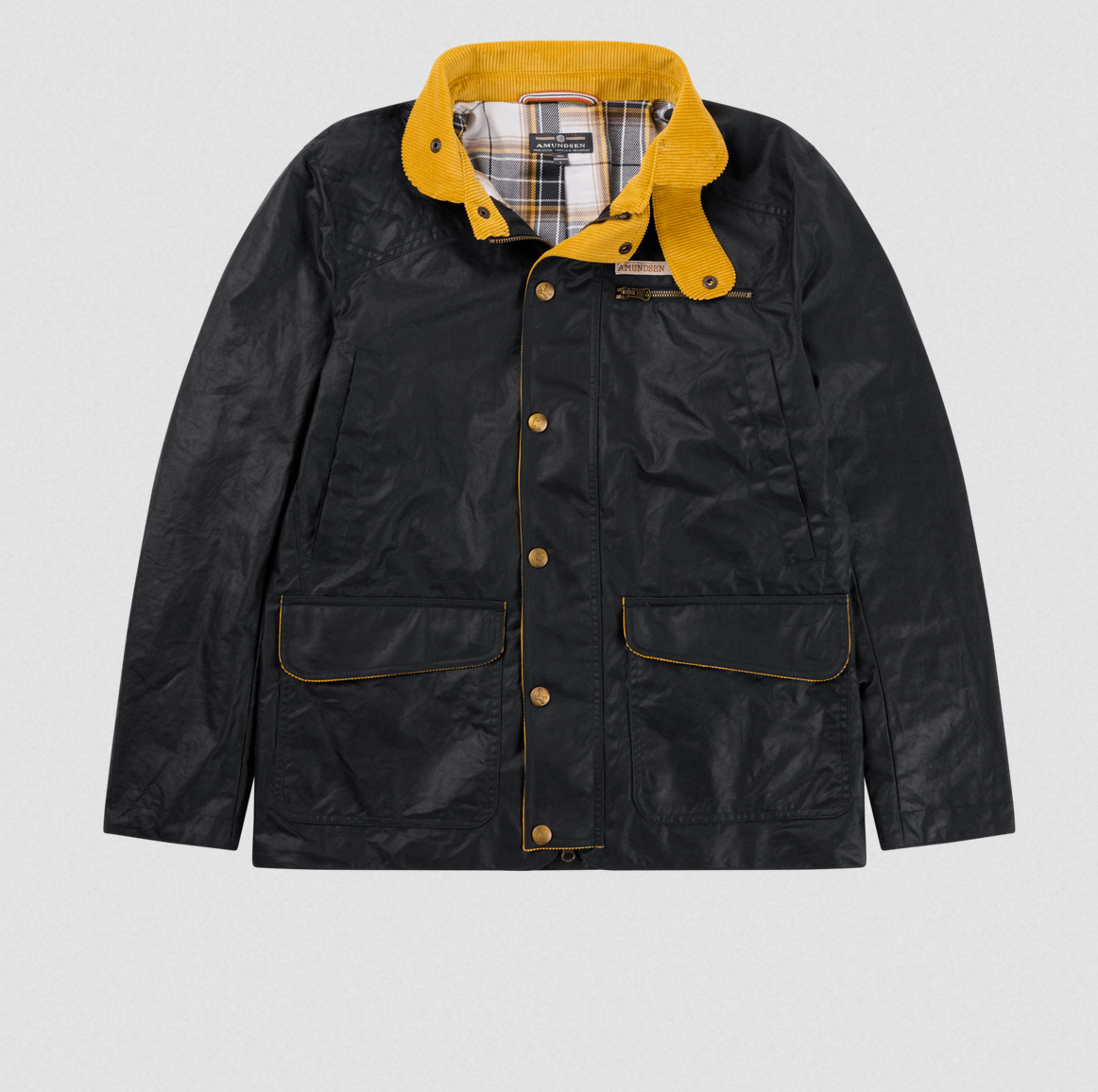 A black waxed cotton jacket with a mustard yellow collar and gold-tone snap buttons, laid flat against a light gray background.