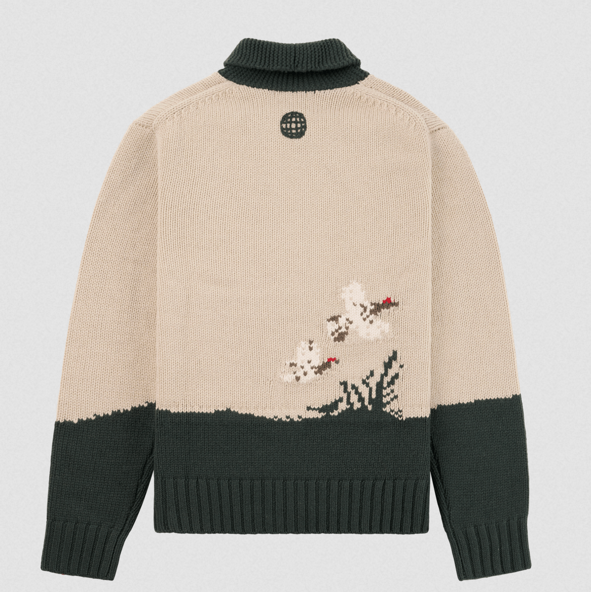 A beige and dark green knit sweater shown from the back, featuring a pixelated floral motif in white, green, and red near the lower back, with a dark green turtleneck collar and ribbed cuffs and hem.