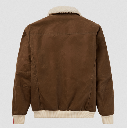 The back view of a brown suede jacket with a cream-colored shearling collar and ribbed knit trim at the cuffs and hem, shown against a light gray background.
