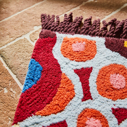 Colorful textured rug with circular patterns on a stone floor
