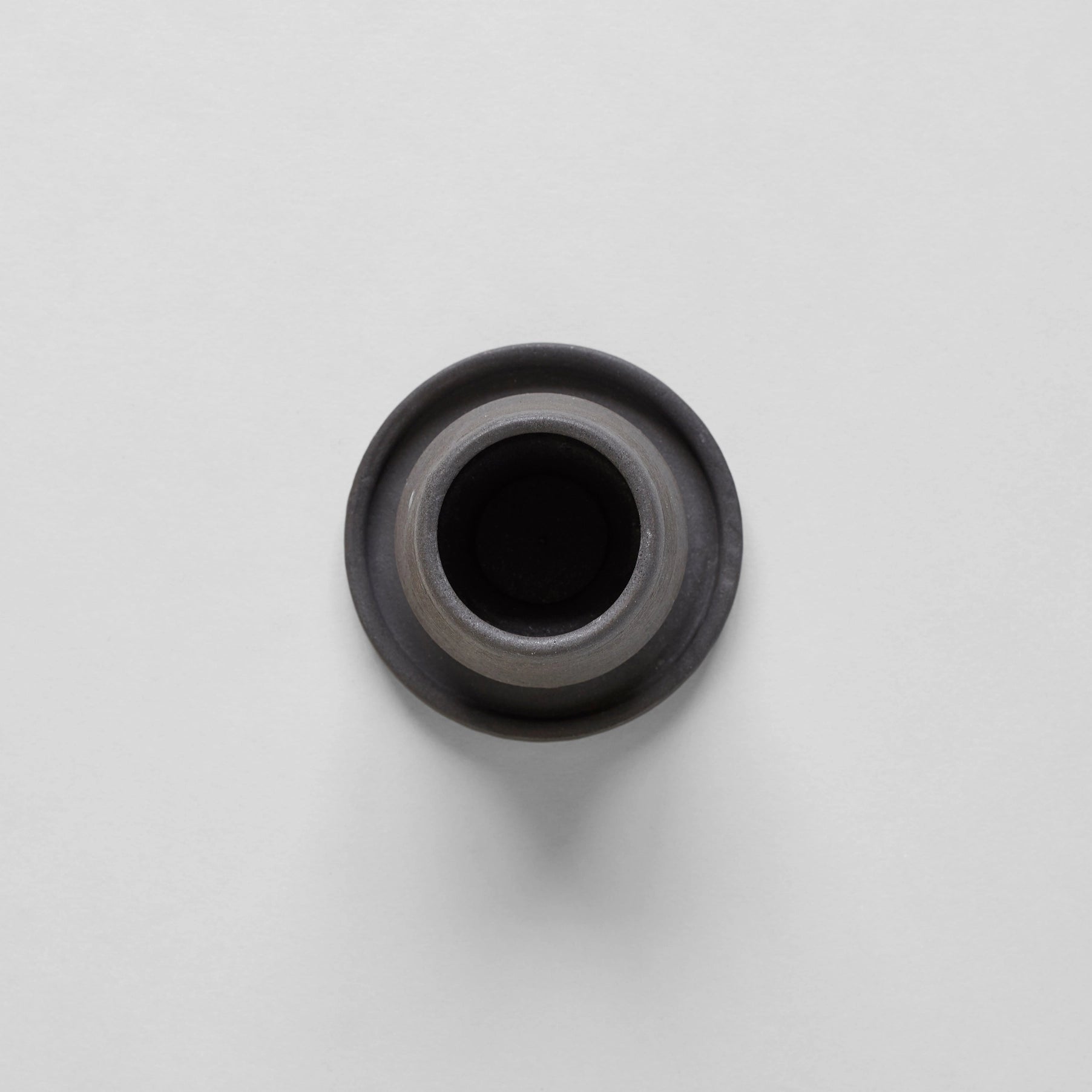 Black ceramic match holder with matches on a gray background. Handmade in the United States and looks lovely as a decorative item. Sold at Huset Shop on Abbot Kinney. 