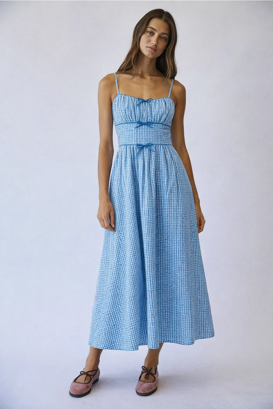 Woman wearing a blue checkered dress on a white background