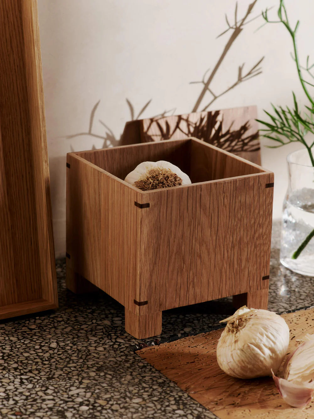 The Bon Garlic Box is a thoughtful addition to the Bon Collection. Crafted from delicate, solid oak sheets, it showcases a refined aesthetic that combines craftsmanship with functionality. The box features precise corner joints and ventilation holes at the base, keeping garlic fresh and dry while protecting it from sunlight. Handcrafted from FSC™-certified wood, the design balances elegance with modern utility, making it a perfect fit for contemporary kitchens.
