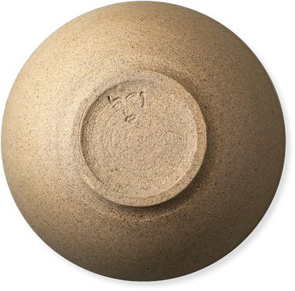 A top-down view of a ceramic bowl with a textured, speckled beige and brown glaze, showing a circular foot ring with a hand-painted signature in the center.