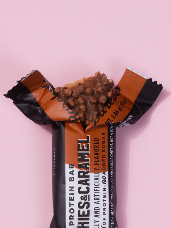Protein bar with chocolate chips and caramel flavor on a pink background