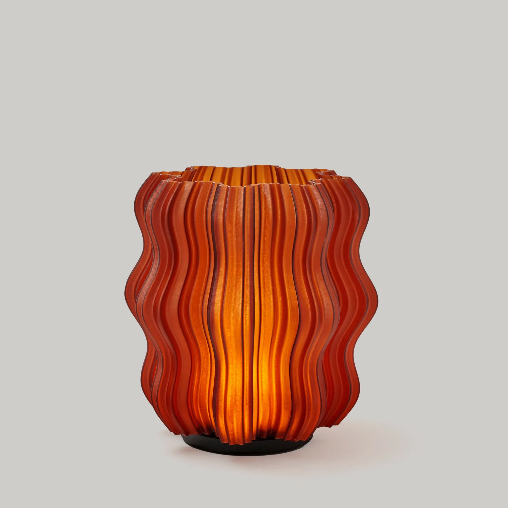 A little lamp with strong opinions about atmosphere.
Please note: Smoke and Amber colorways appear less bright than Clear as the filament is darker and more opaque.&nbsp;
Scaled down but not simplified, the Mini Wavy carries the same sculptural rhythm as its big brother. It’s content to sit anywhere light belongs — beside a bed, behind a book, or in that neglected corner that suddenly looks intentional.