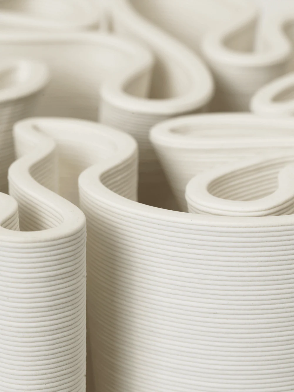 Echoing the elaborate patterns of a 'Dédales' or labyrinth, the Dedali Vase is a fusion of art and utility. Crafted from 3D-printed ceramic, its labyrinth-like top is not only aesthetically pleasing but also functional for arranging flowers in a voluminous, Ikebana-style.