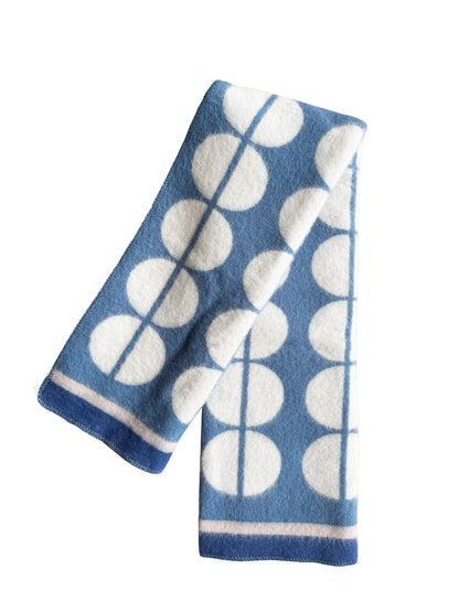 A blue and white patterned knit scarf with a geometric design of large white circles and vertical lines, shown on a plain white background.