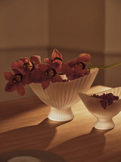 White ceramic bowl with pink flowers on a wooden surface