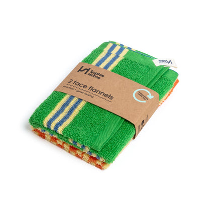 Pack of two face flannels with a green towel and multicolored towel, wrapped in brown paper with 'Nathalie Home' branding.