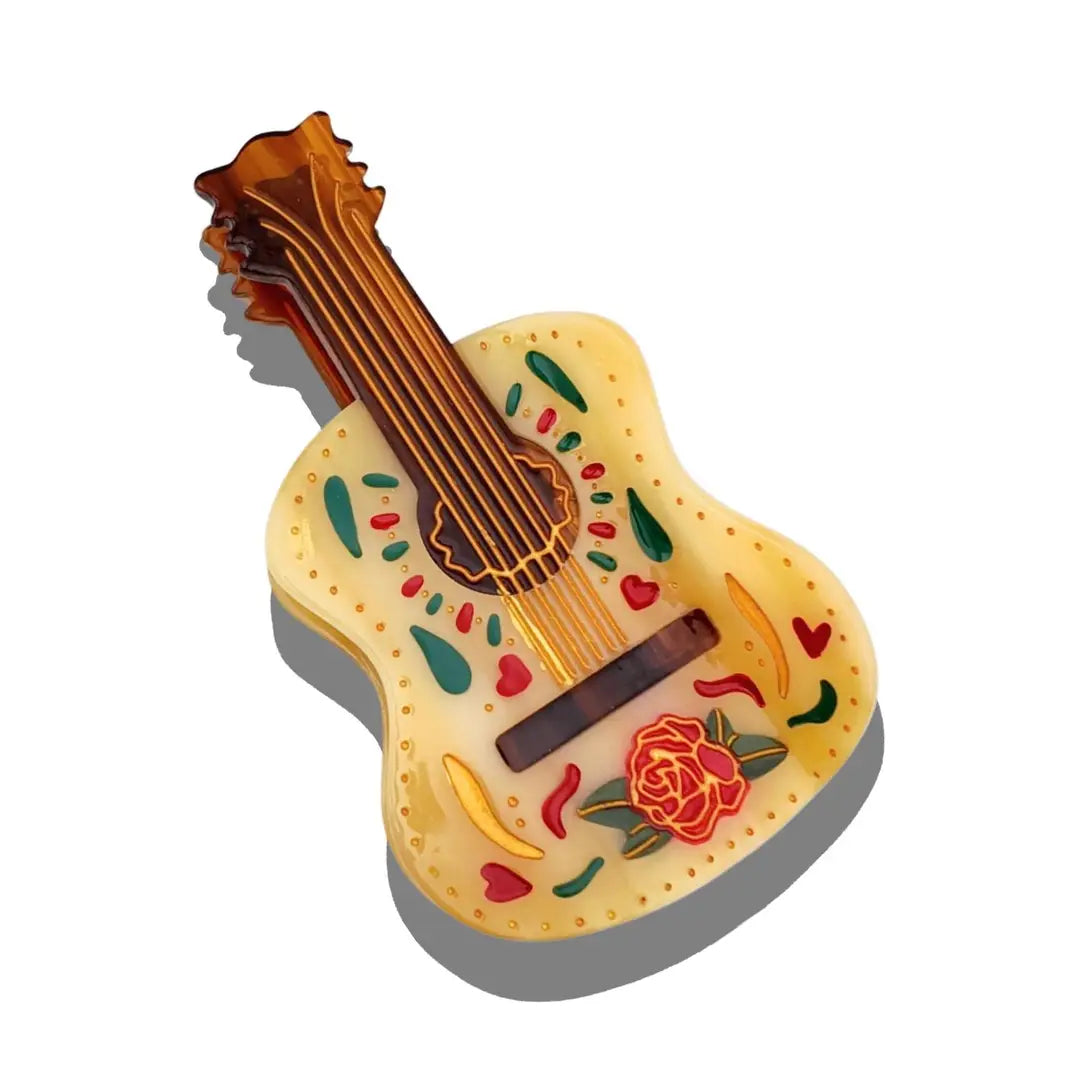 Decorative guitar-shaped object with floral patterns on a white background