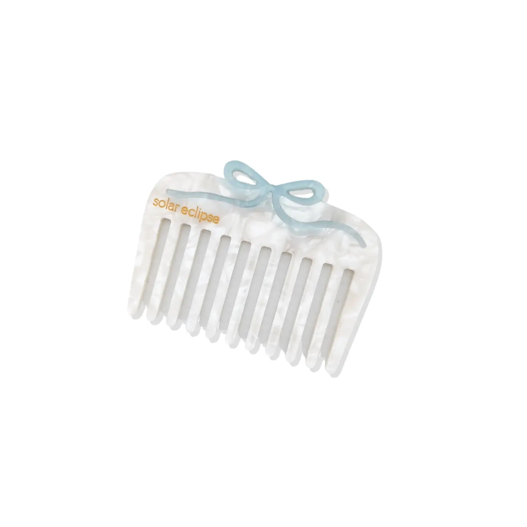 White hair comb with a blue bow on a white background Each hair comb is hand-painted by Solar Eclipse artists. These combs are made of cellulose acetate, an eco-friendly, biodegradable material made from recycled wood pulp. Perfect for gently detangling without causing breakage, promoting hair growth and increasing circulation. Suitable for all hair types including wavy and curly hair.