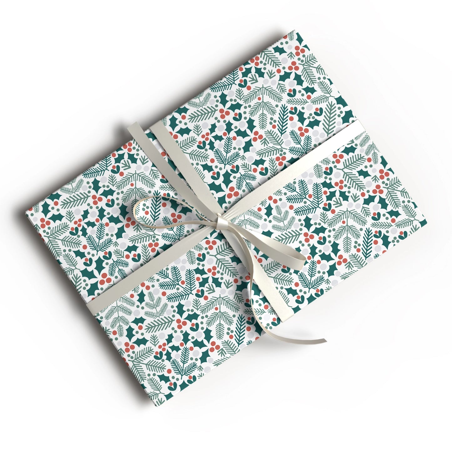 A gift box wrapped in festive holiday paper with a green and red holly and pine pattern, tied with a cream ribbon, shown on a white background.