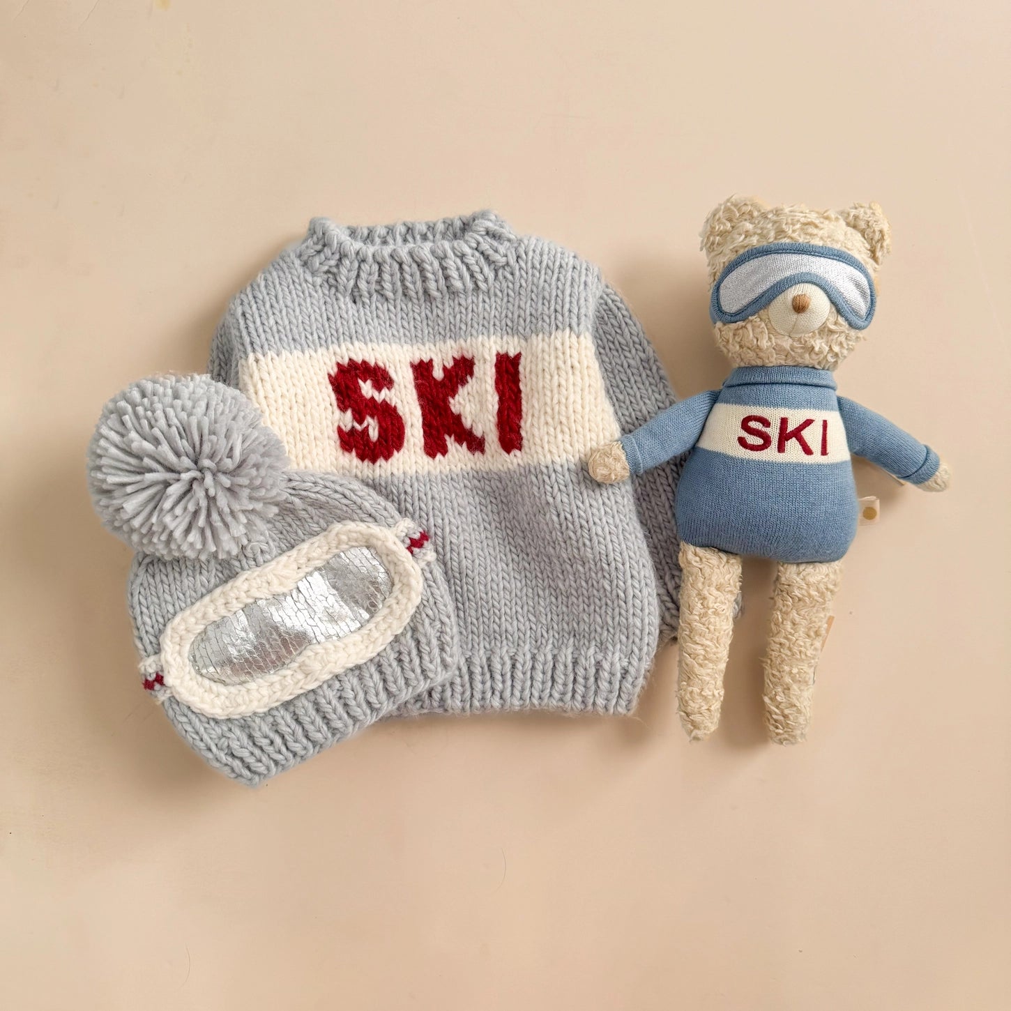Knitted ski outfit with 'SKI' text on a beige background