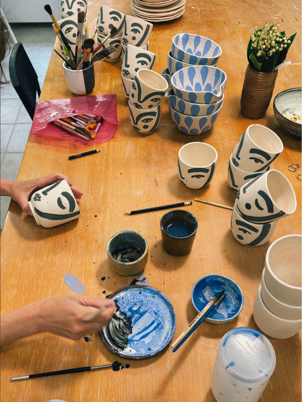 Painting ceramic mugs on wooden table