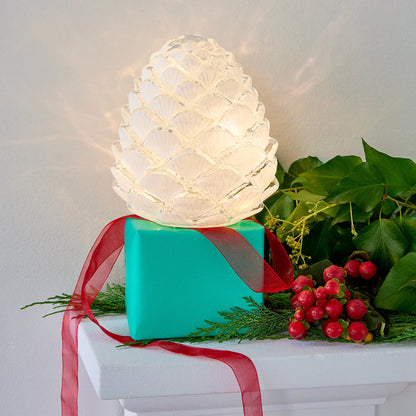 Decorative frosted glass pinecone light that uses batteries and lights up for a beautiful cozy ambiance in any space. Perfect for the holiday season and placing on a tablescape or on a mantel. 