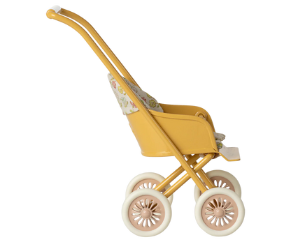 Yellow toy stroller with floral pattern on a white background