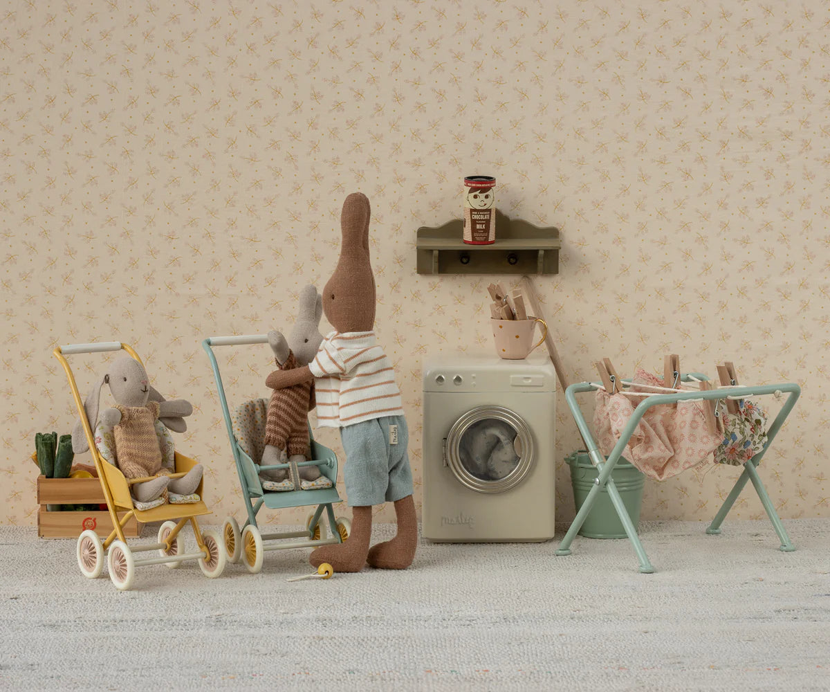 Miniature scene with teddy bears and toys in a room setting.