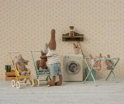 Miniature scene with teddy bears and toys in a room setting.