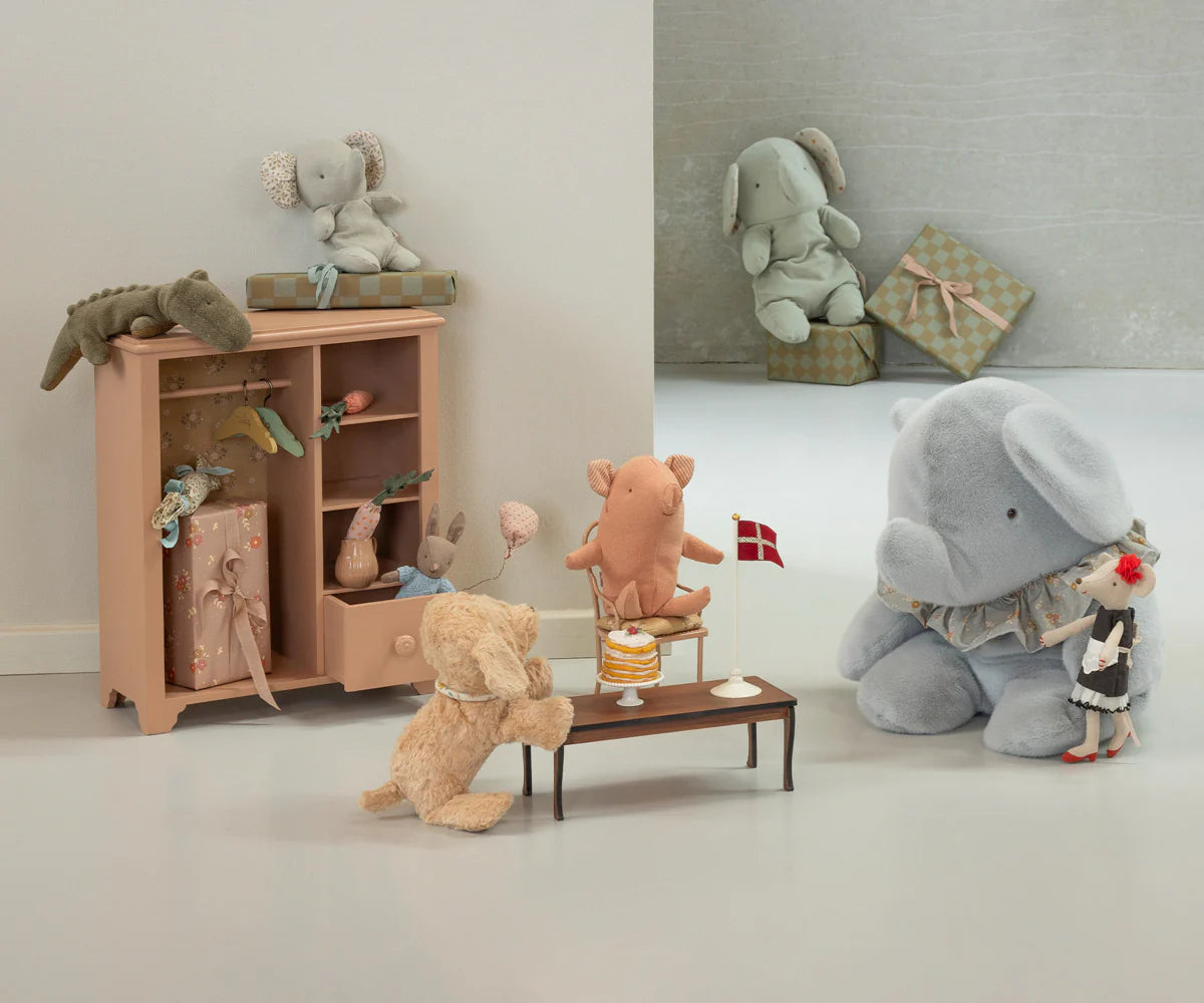 Children's room with toy furniture and plush toys including a elephant, bear, and pig.