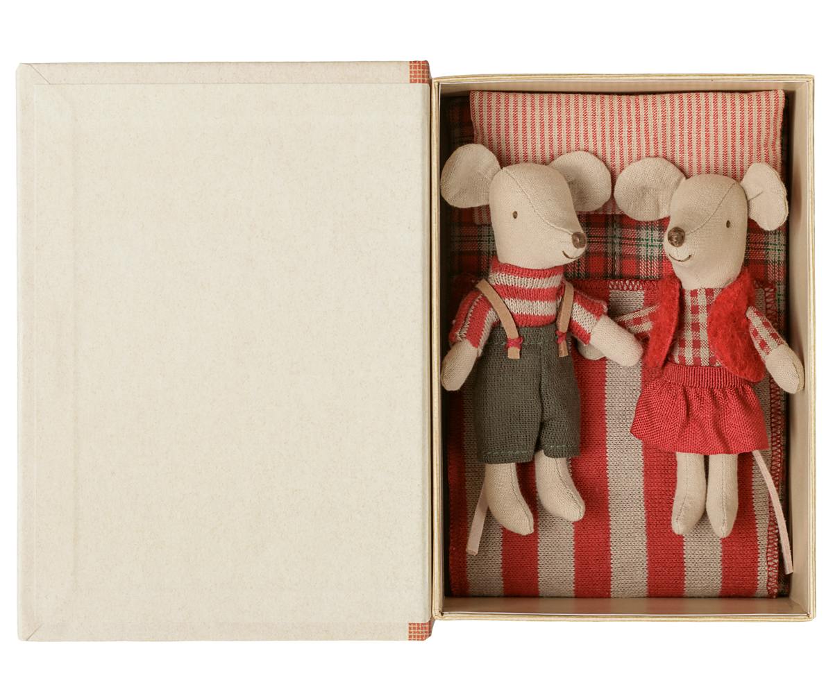 two plushie mice in bed with red pillow and blanket 