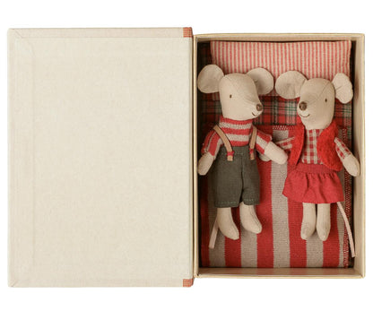 two plushie mice in bed with red pillow and blanket 