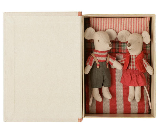 two plushie mice in bed with red pillow and blanket 
