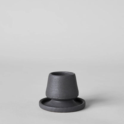 Black ceramic match holder with matches on a gray background. Handmade in the United States and looks lovely as a decorative item. Sold at Huset Shop on Abbot Kinney. 