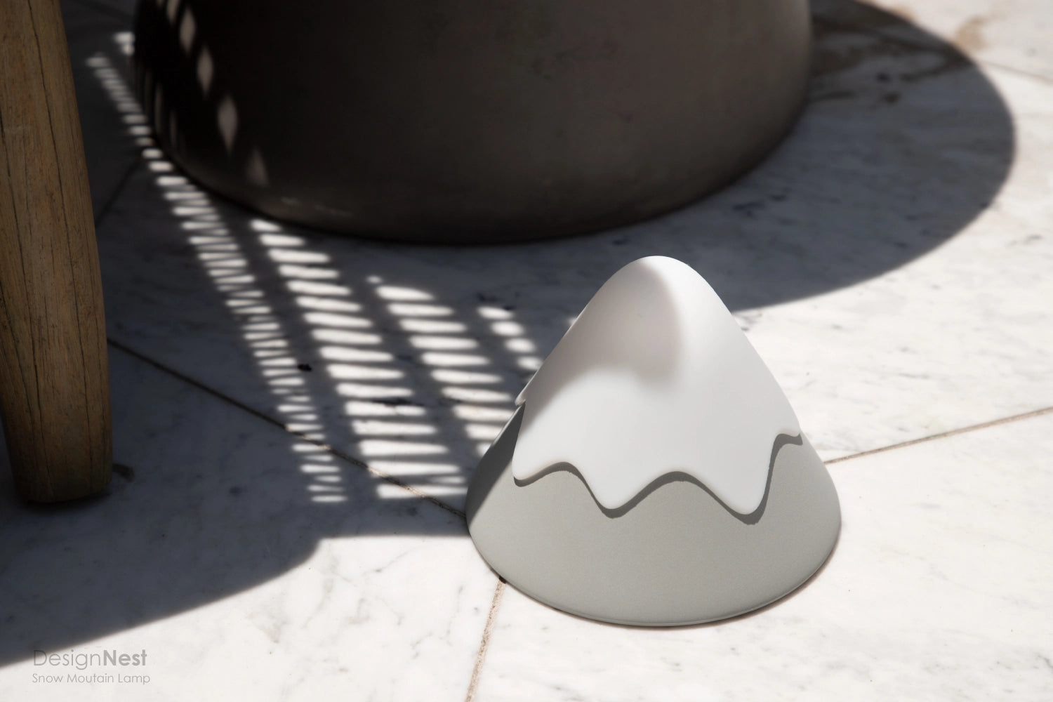White ceramic mountain-shaped object on a light surface with shadows 