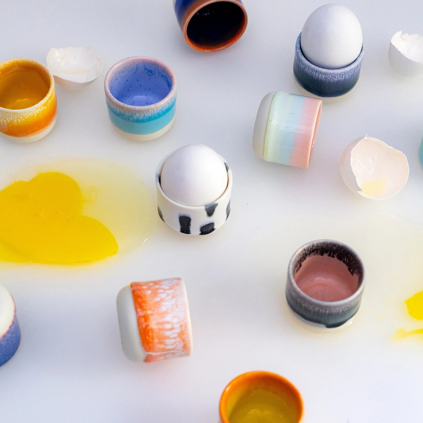 Colorful ceramic containers on a white surface
