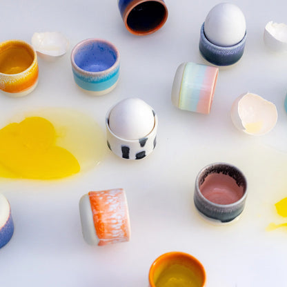 Colorful ceramic containers on a white surface