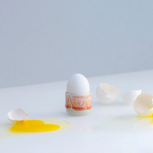 Broken egg with yolk on a white surface