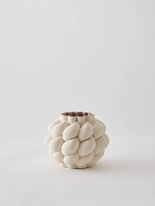 Nuvola is a nature-inspired 3D-printed vase in porcelain clay. It is shaped with soft, curving lines and a rounded profile that creates a lively feel. Through 3D printing, each vase achieves precise lines and an intricate form that is difficult to achieve by hand. The interior is treated to hold water, but as the clay is naturally porous, some moisture may seep through. Therefore, avoid placing it on delicate surfaces.