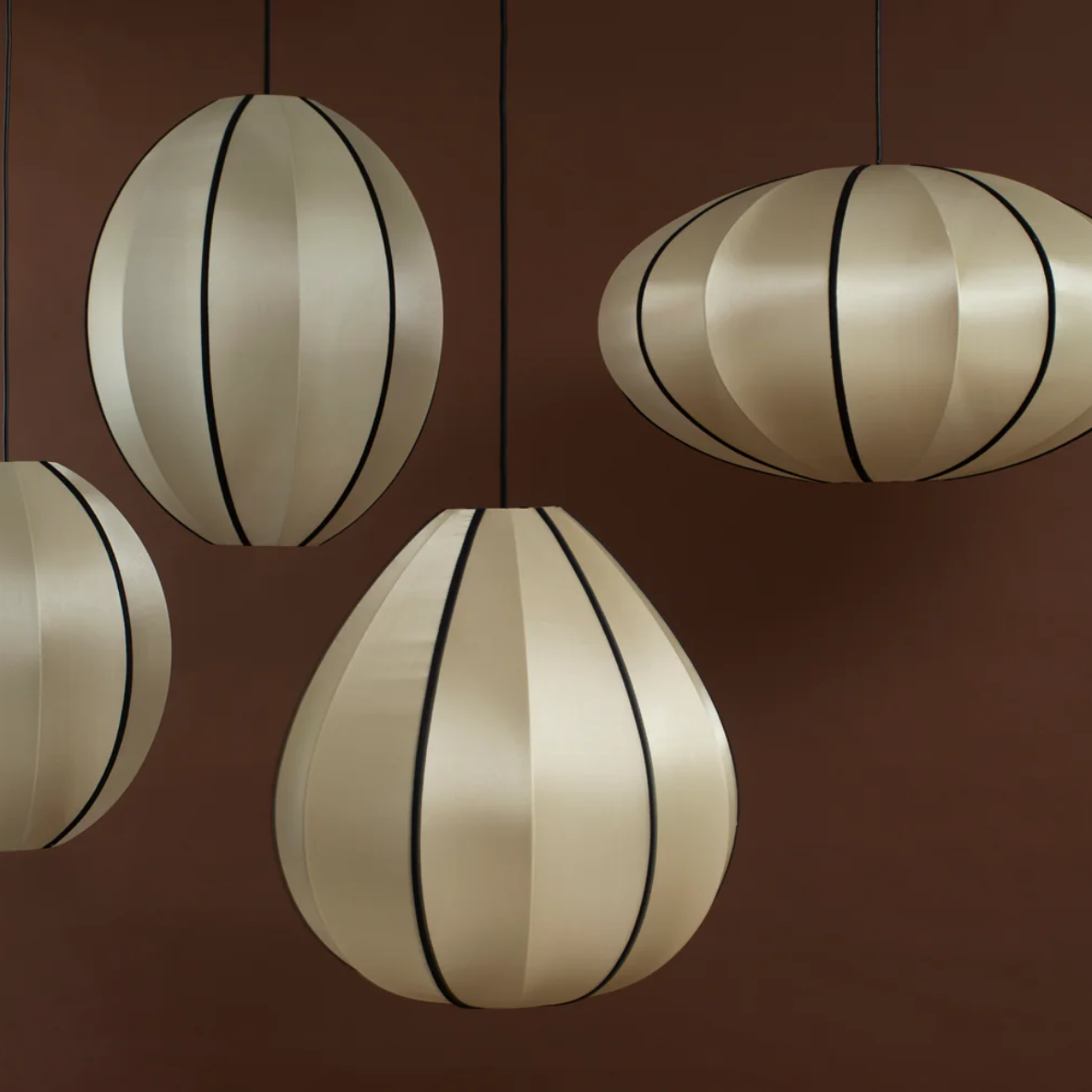 Four spherical pendant lights with striped design on a brown background
