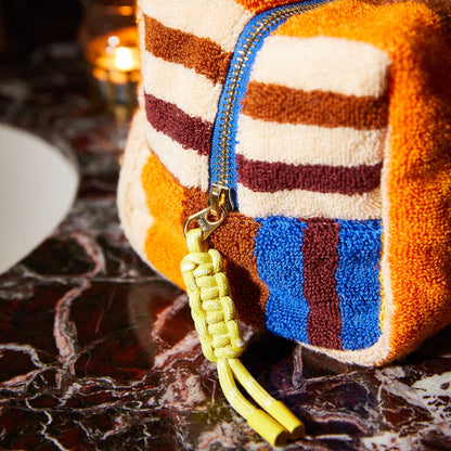 Colorful textured pouch with a yellow strap on a dark surface